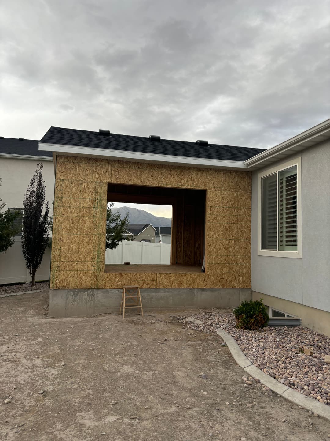 Home renovation in progress with an open framed wall and scaffolding outside.